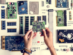 Aerial view of hands with computer electronics parts on white background